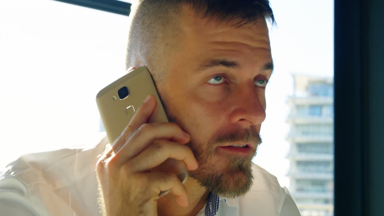 Male executive talking on mobile phone in office 4k
