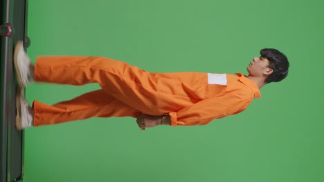 side view full body of asian male prisoner in handcuffs walking on the green screen background