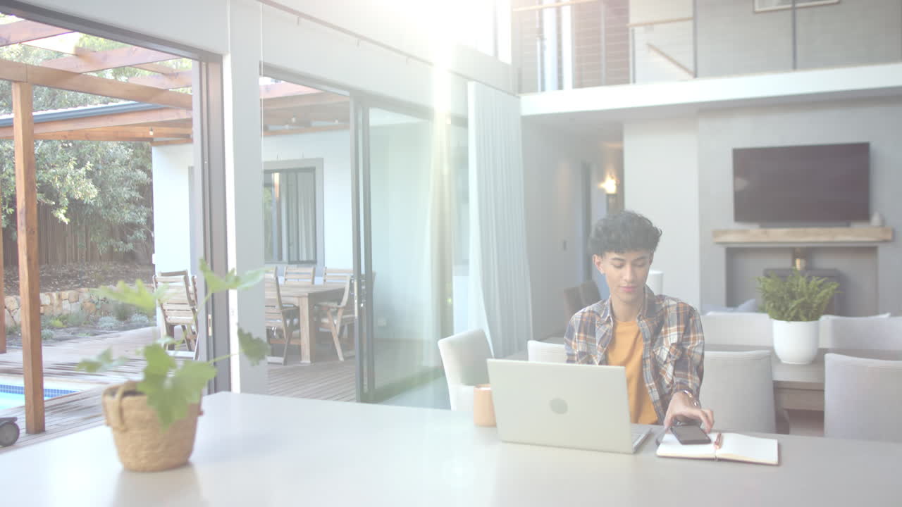 Working from home, teenage boy using laptop and mouse in modern living space, copy space
