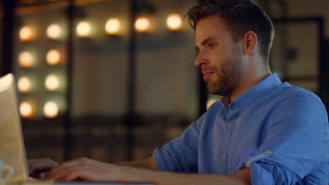 Inspired-man-typing-on-laptop-in-office.-Guy-pondering-ideas-in-meeting-room.