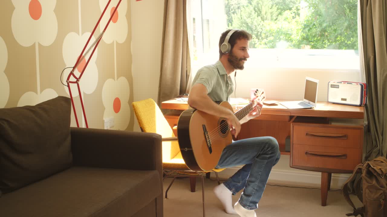 4k video footage of a young man recording himself playing guitar