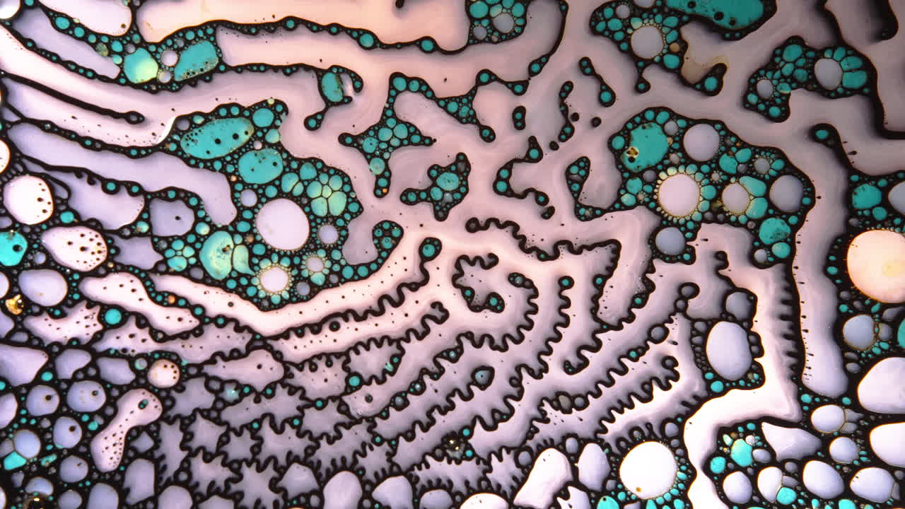 Abstract macro shot of colorful liquids mixing, forming intricate patterns and bubbles