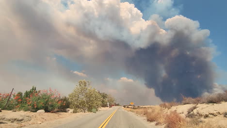 pov shot, car driving along countryside road towards smoke plumes from california fires