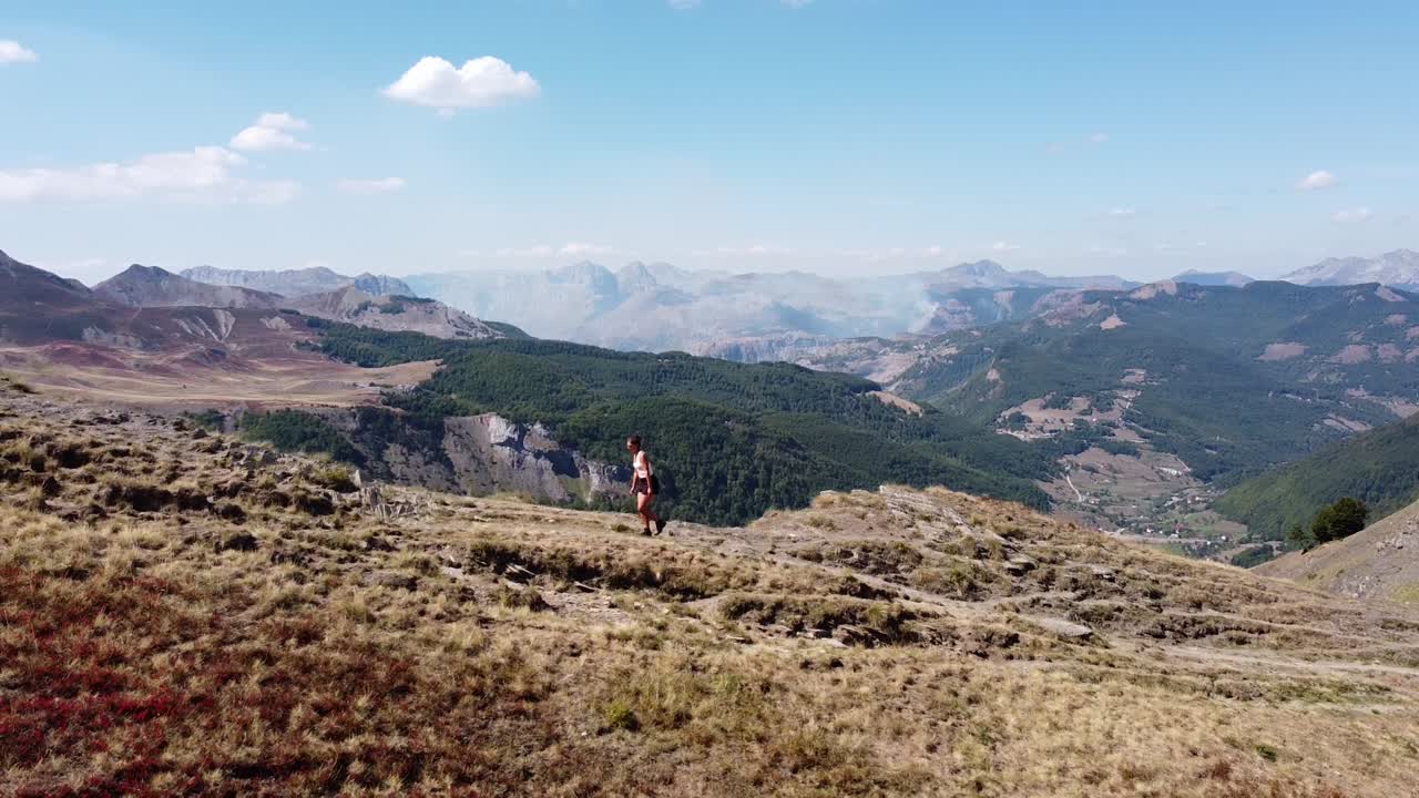 mujer camina cuesta arriba por un sendero de montaña en el parque nacional de prokletije, montenegro - pan circular aéreo