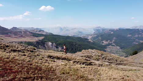 woman hikes uphill a mountain trail in prokletije national park, montenegro - aerial circling pan