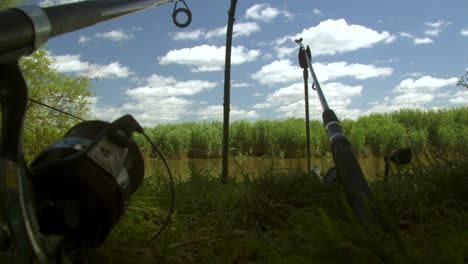 tiro de ángulo bajo de dos cañas de pesca en una orilla de un río en una sesión de pesca