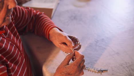 4K-video-of-an-elderly-women-holding-the-holy-rosary-and-praying-next-to-the-Holy-Bible