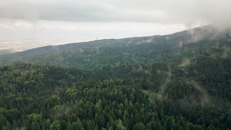 Drone-Flying-Toward-the-city-of-Sofia-Above-the-Vitosha-Mountain-with-Heavy-Mystical-Fog-Rising-from-Trees