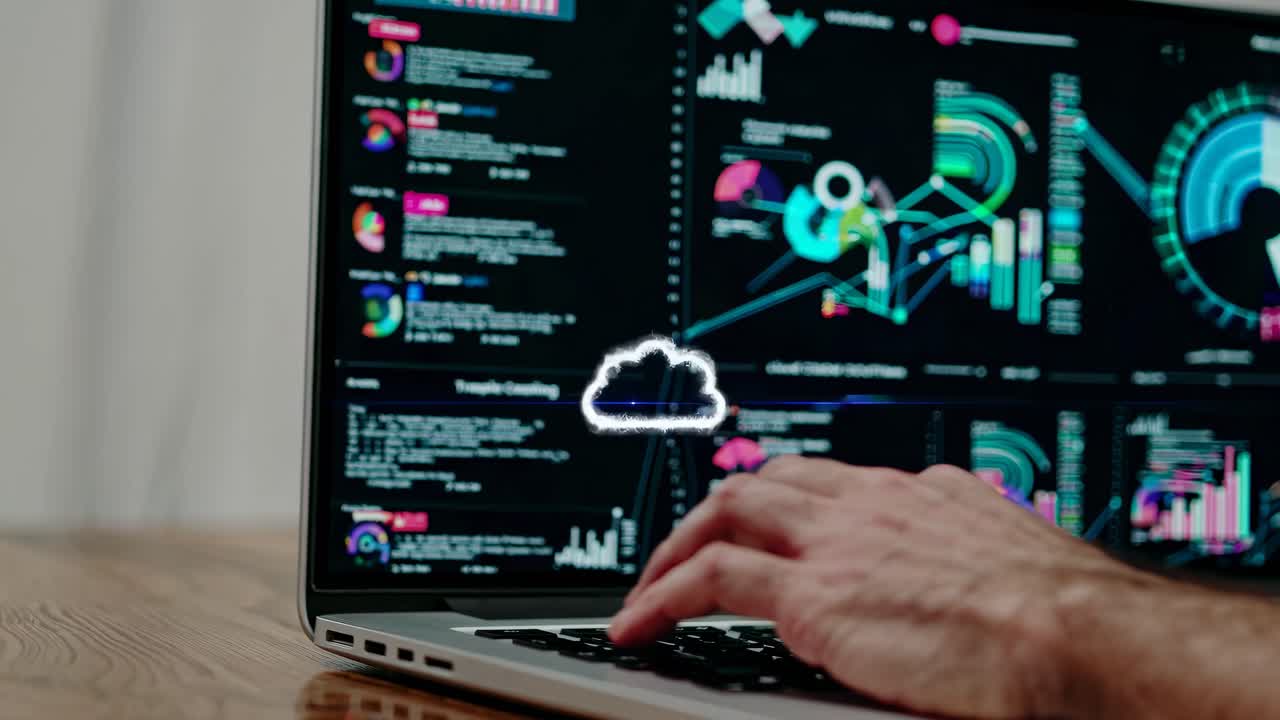 A close-up video of hands typing on a laptop, displaying colorful data analytics on the screen