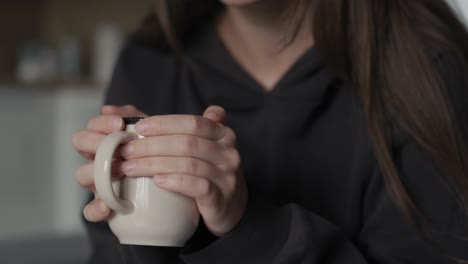 close up of woman's hands which holding cup of tea.