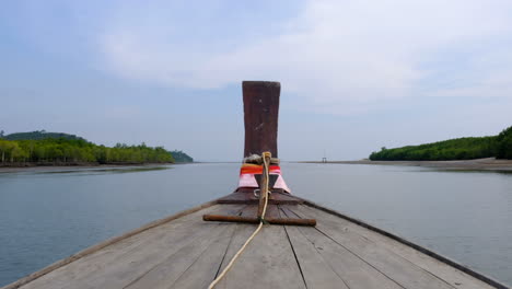 shot of the front of a wooden boat in thailand dropping off tourists at their destinations