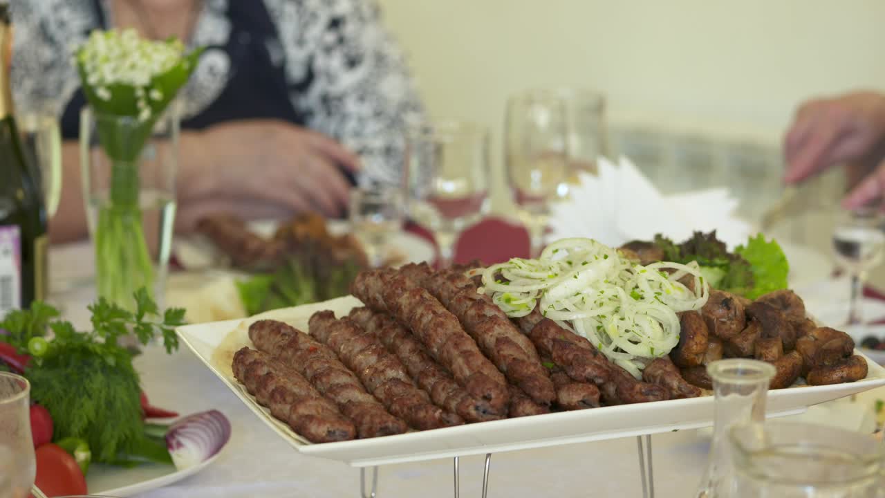mesa de cena servida con kebabs lula y verduras frescas