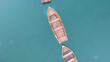 Drone-Vuela-Sobre-Botes-De-Remos-De-Madera-En-El-Famoso-Lago-Braies,-Italia-En-Dolomitas