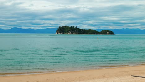 Seaside-allure:-Boat-gliding-past-an-island-in-captivating-stock-footage-at-Abel-Tasman-National-Park