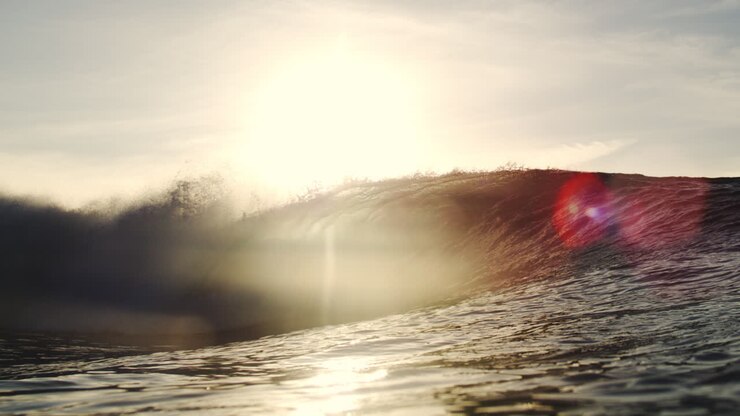Slow Motion Ocean Wave Breaking with Golden Sunlight and Lens Flare