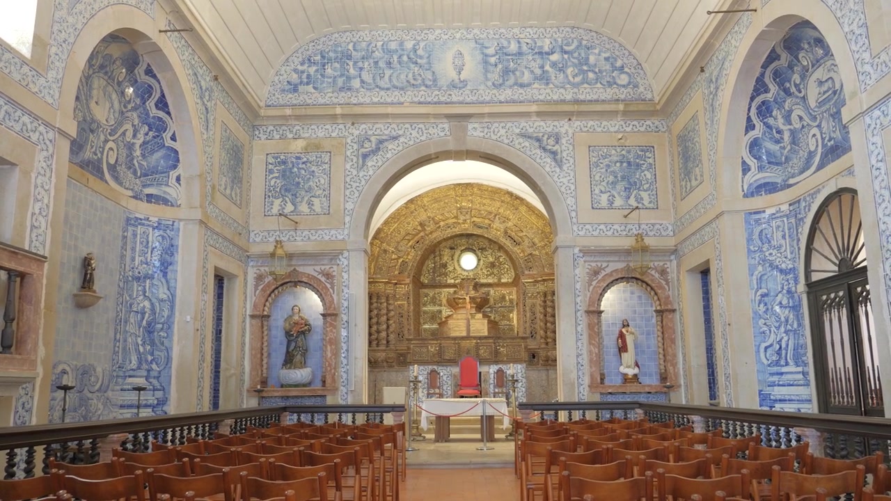 Santa Maria do Castelo church interior with blue azulejo panels gilded altarpiece and wooden pews