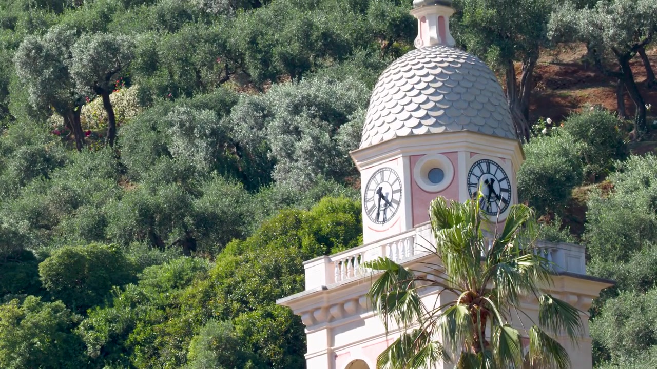 Torre del reloj histórica rodeada de exuberantes árboles verdes