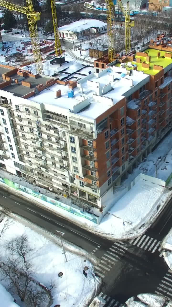 Newly constructed building. Crane and building construction site in winter