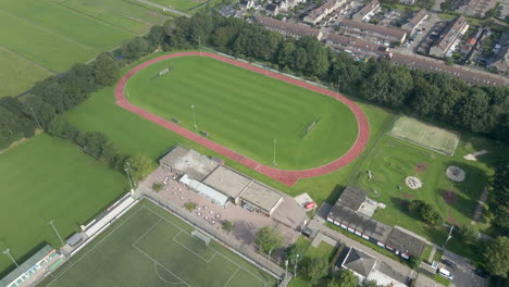 cinematic aerial of running track on green sports field