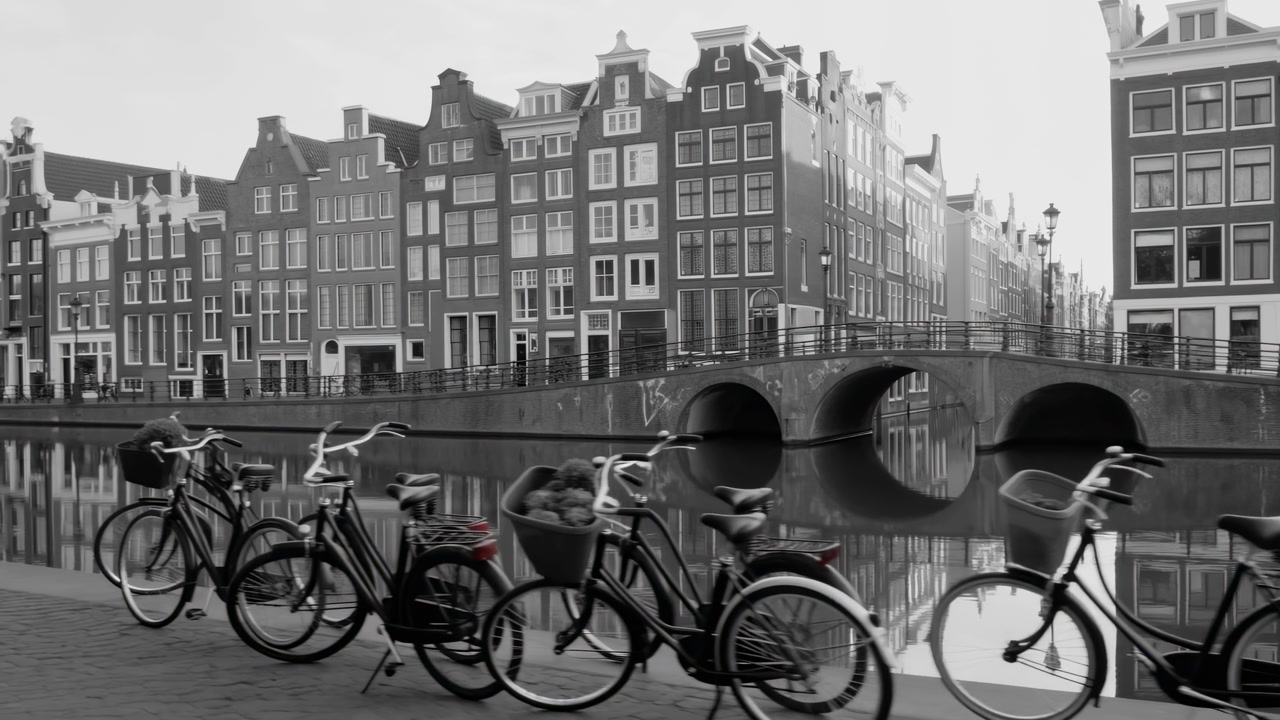 Bicycles Lined Along Amsterdam Canal Bridge, Monochrome Morning Reflection Of Gabled Houses In Water, Tranquil