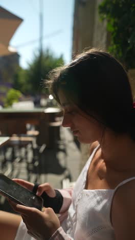 joven usando una tableta en un café al aire libre