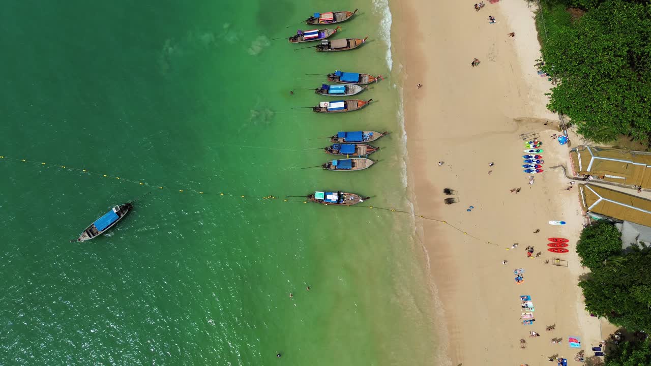 Traditional Thai longtail boats moored on Railay Beach Thailand, aerial drone view