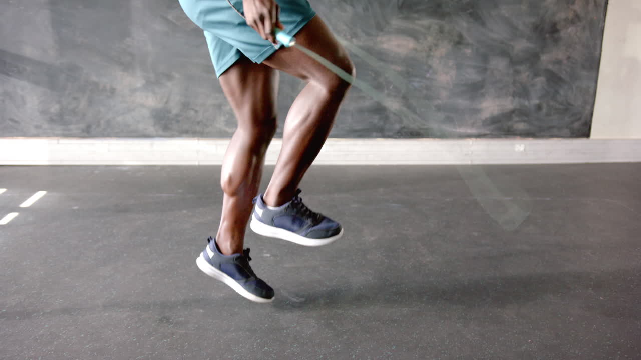 Exercising, african american man in athletic shorts performing high knees in gym, copy space