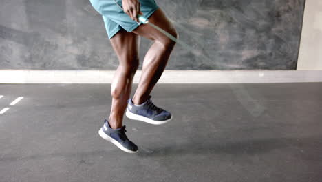 exercising, african american man in athletic shorts performing high knees in gym, copy space