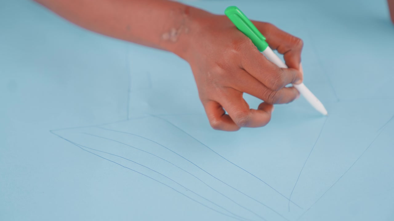 Precise sewing instructions. Steadyhanded mother intricately marks fabric using stylus for sewing. Focused mother systematically punctuates blue textile with stylus for accurate garment shaping