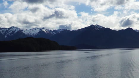 lake water of manapuri and mountain ranges in new zeland, pan left view