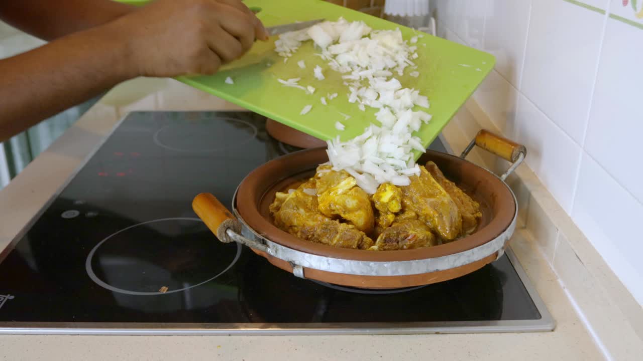 el hombre cocina en casa y prepara un plato con cebolla