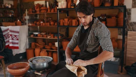 ceramist uses potter's wheel and creates a handmade clay product