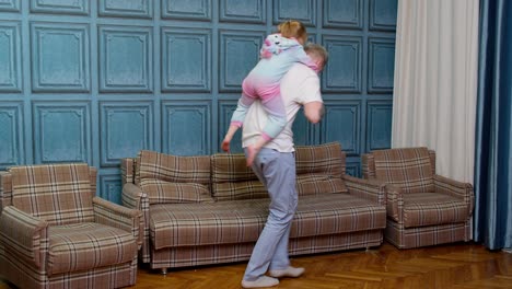 happy family father and child kid daughter dancing, playing piggyback, running, riding at home