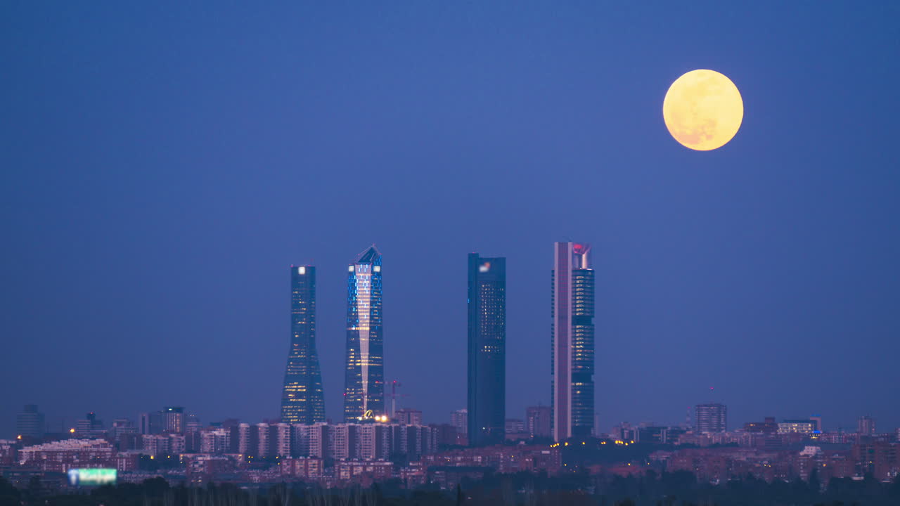 luna saliendo sobre las cuatro torres en madrid, españa
