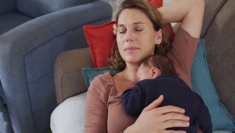 Video-De-Una-Madre-Caucásica-Cansada-Durmiendo-En-Un-Sofá-Con-Un-Bebé-Recién-Nacido