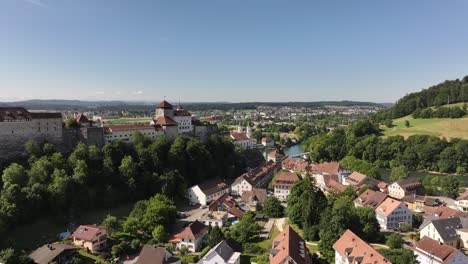 drone aerial of aarburg castle, historic old town and aare river in canton solothurn, switzerland, surrounded by lush green hills and scenic landscapes
