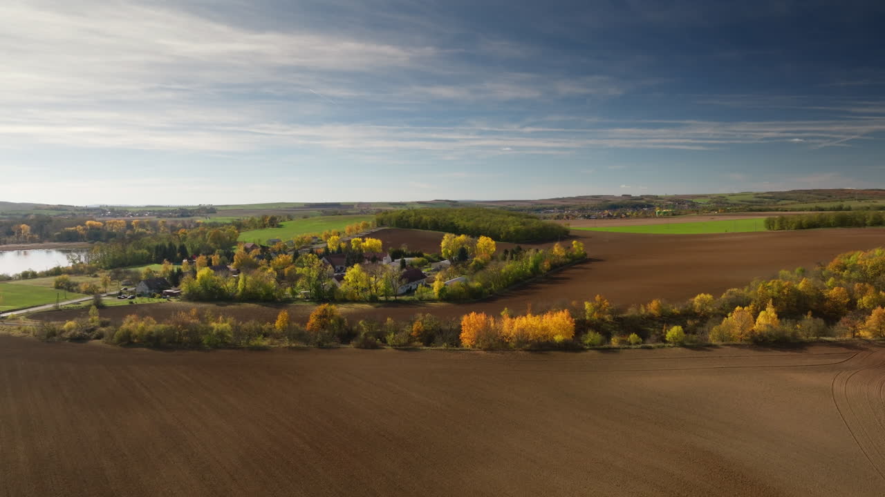Drone aerial of wide autumn farmland and tree lines in Czech Tuscany near Moravsky Krumlov, Czech Republic