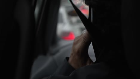 view behind passenger talking on phone in car on rainy day