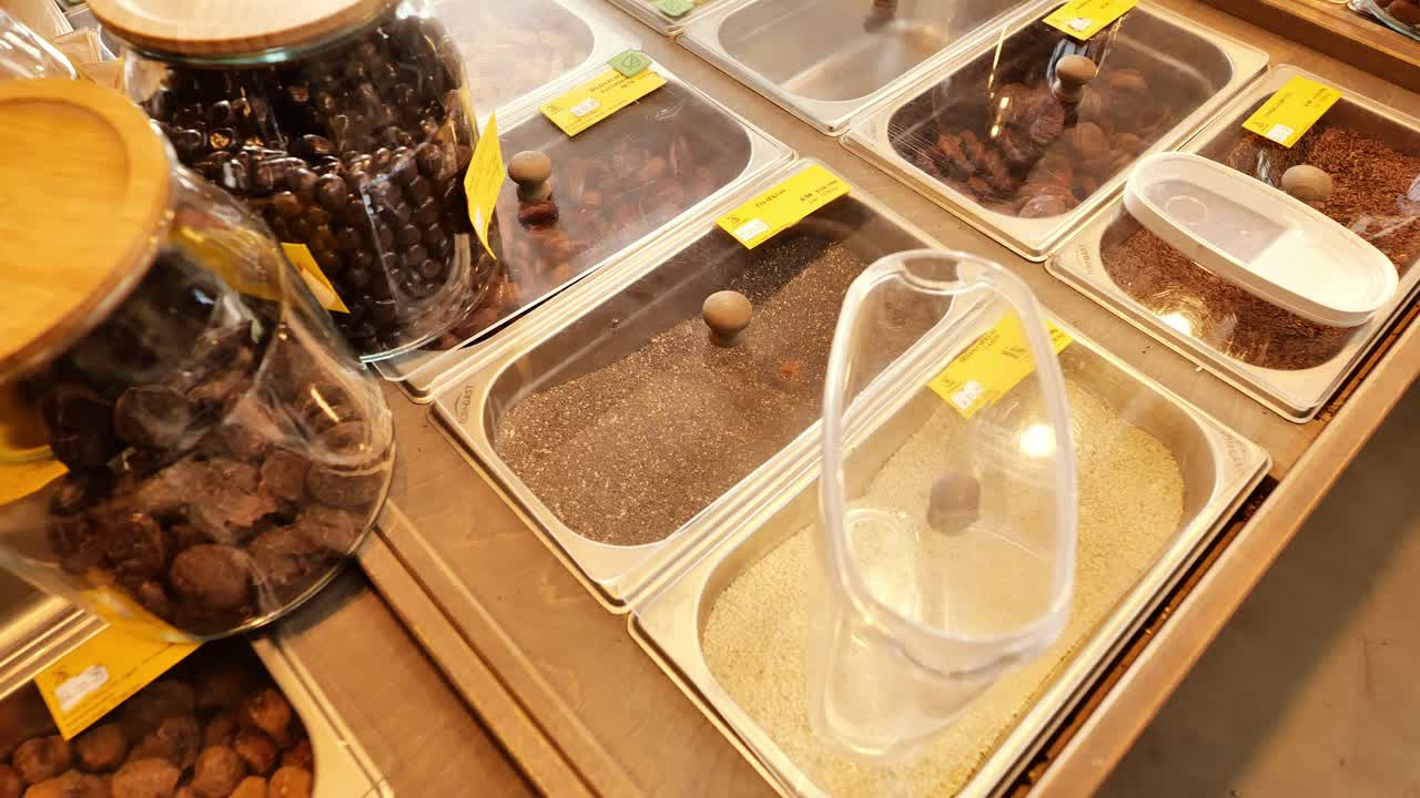 Slow motion moment as woman carefully places jar to fill at eco refill shop