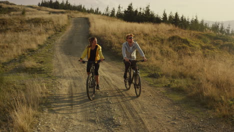 Sportler-Radeln-Auf-Mountainbikes.-Lächelnder-Mann-Und-Frau,-Die-Miteinander-Reden