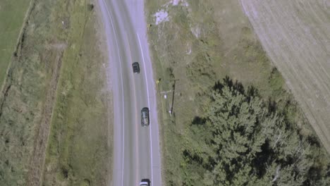 aerial dolly roll over interstate freeway with 2 way traffic forking out to a commercial road with lumber jacks freightors and industrial open top sand trucks headed into a commercial path