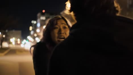 an intimate conversation under city lights: a dramatic exchange between two figures in a dimly lit urban scene