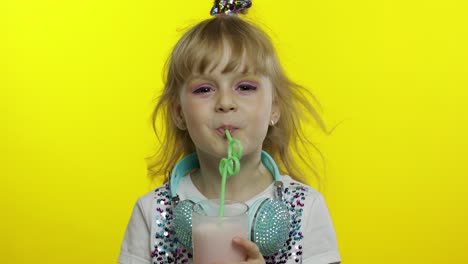 stylish happy child with milk cocktail. tourist drinking fresh beverage milkshake drink using straw