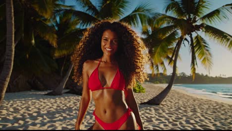 mujer en bikini rojo en una playa tropical al atardecer
