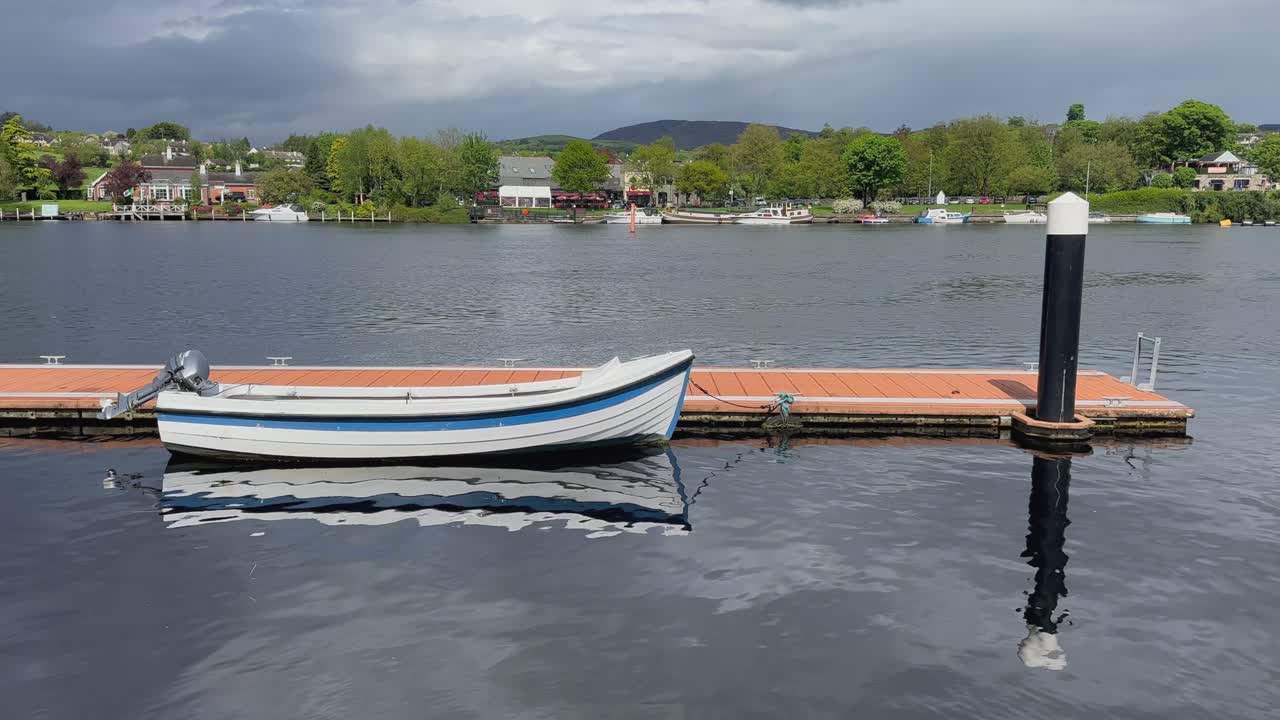 motorboat de lamas de madera atado a un muelle flotante en el río shannon en irlanda