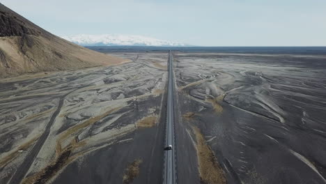 Vista-Aérea-De-Una-Conducción-De-Cuatro-Ruedas-En-Una-Calle-Vacía-En-Un-Hermoso-Paisaje-En-Islandia