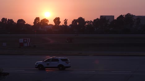 airport security driving by in the sunset