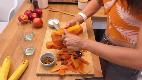 woman peeling and preparing papaya