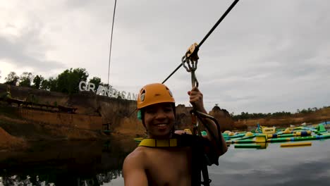 tourist ziplining in the grand canyon water park in chiang mai, thailand - selfie shot