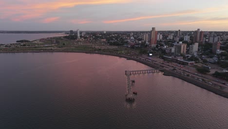 amazing aerial sunset view over the modern riverside cityscape with pier in posadas, misiones, argentina.
